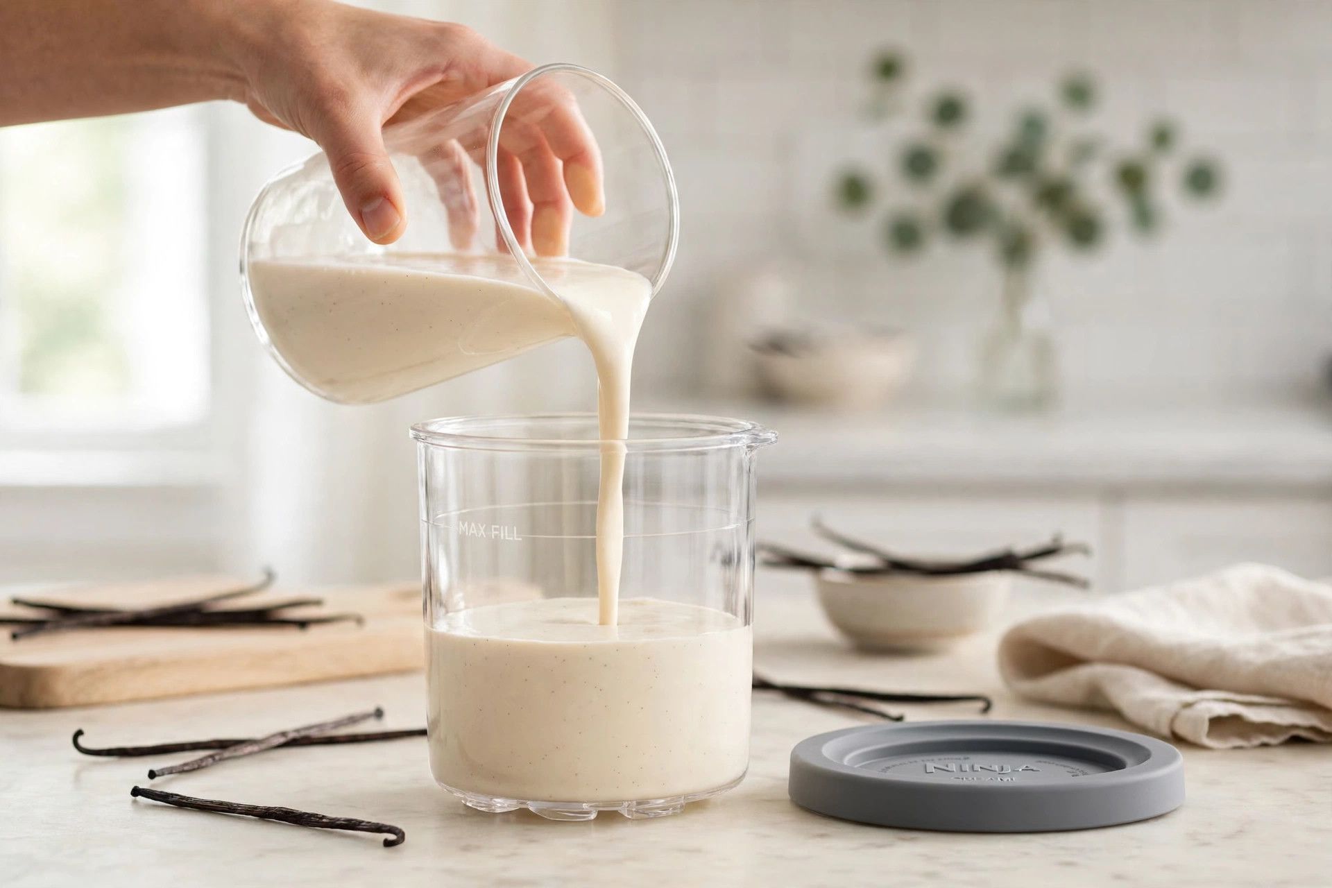 Pouring the smooth protein milkshake base from a blender jug into a Ninja Creami pint container