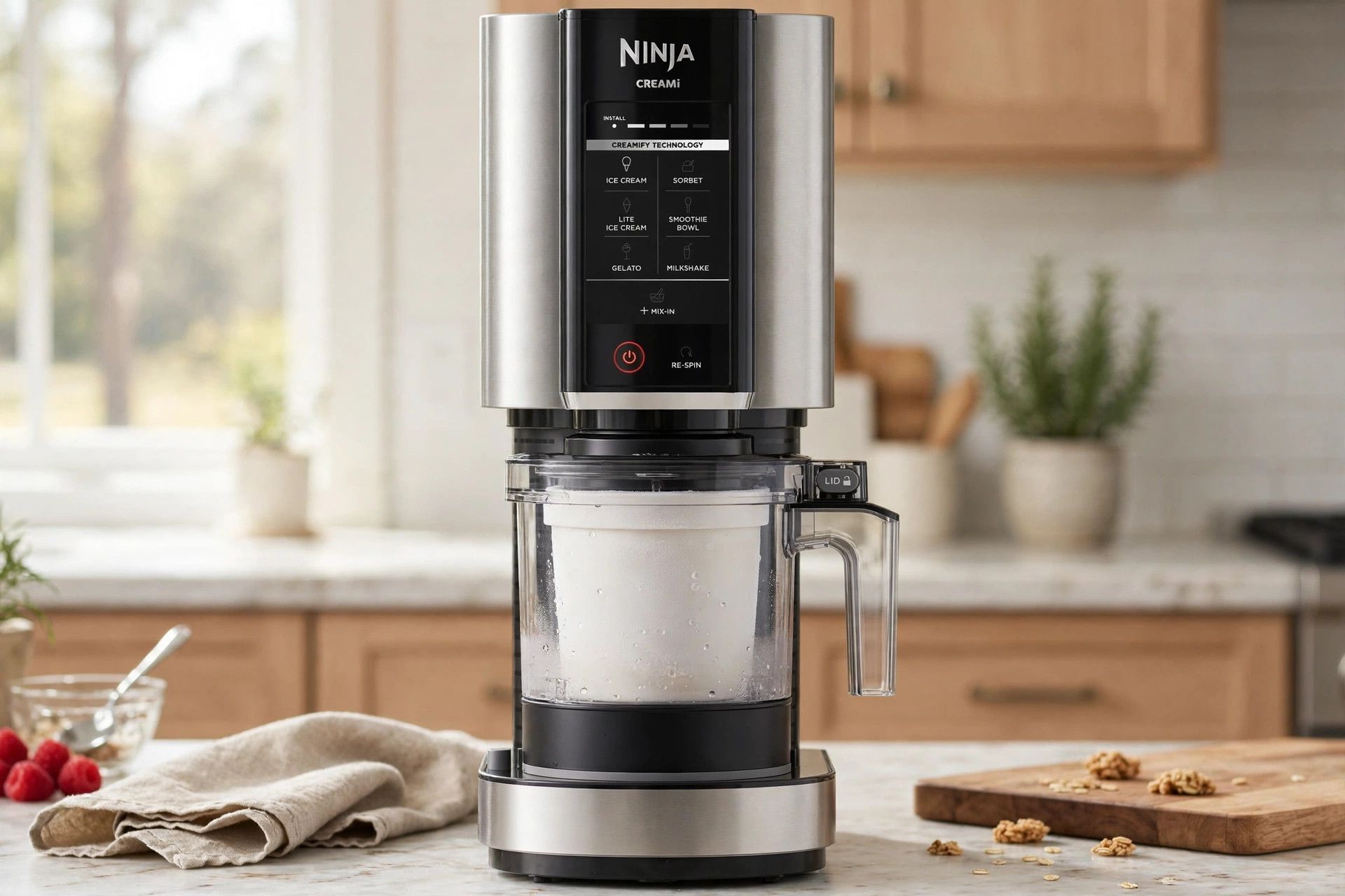 The frozen birthday cake pint loaded into a countertop Ninja Creami machine, ready to spin