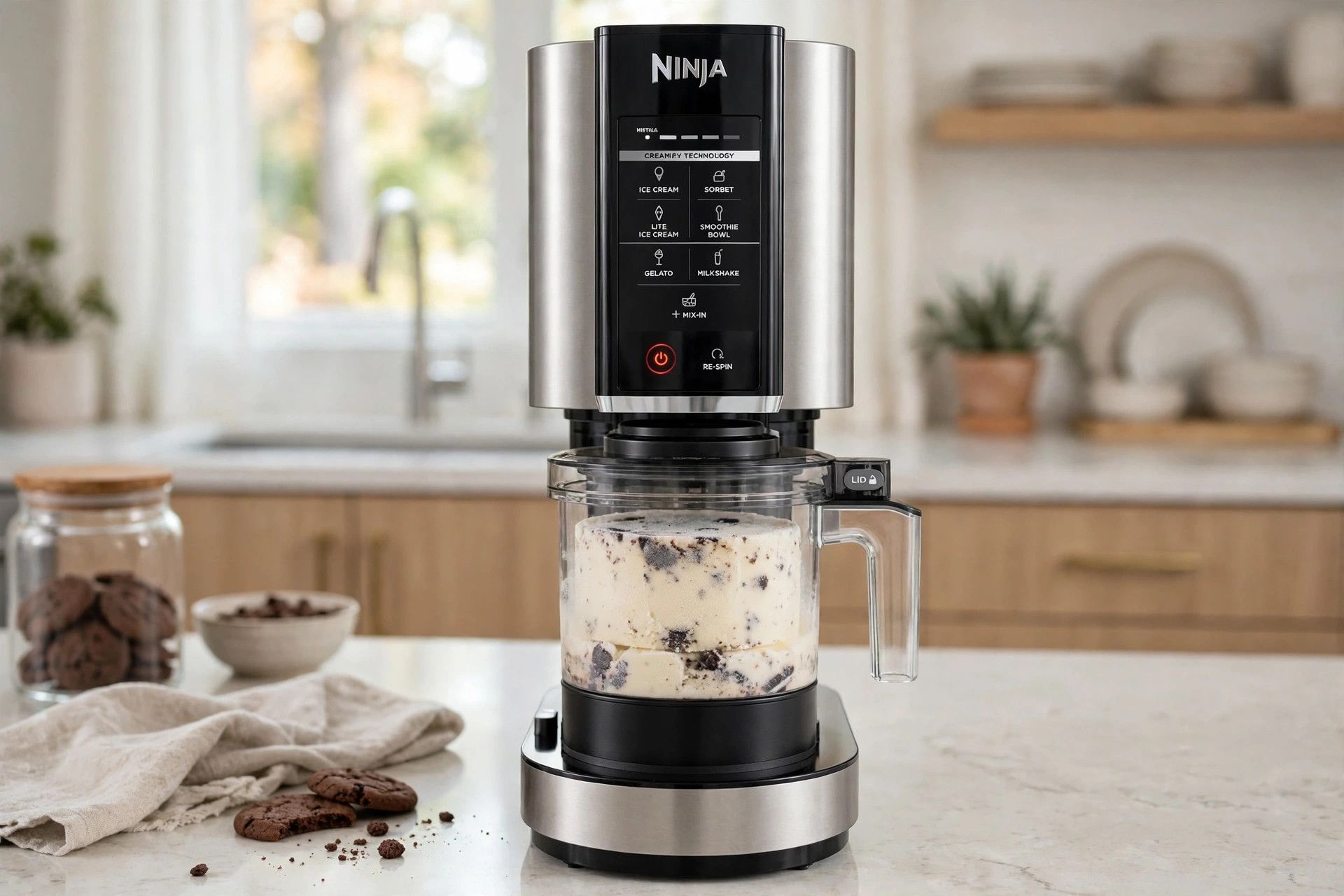 The frozen cookies and cream pint loaded into a countertop Ninja Creami machine, ready to spin