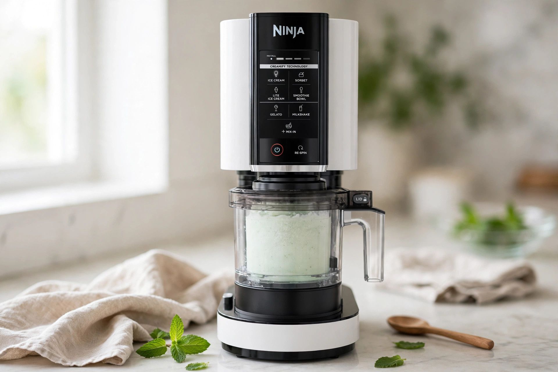 The frozen mint pint loaded into a countertop Ninja Creami machine, ready to spin