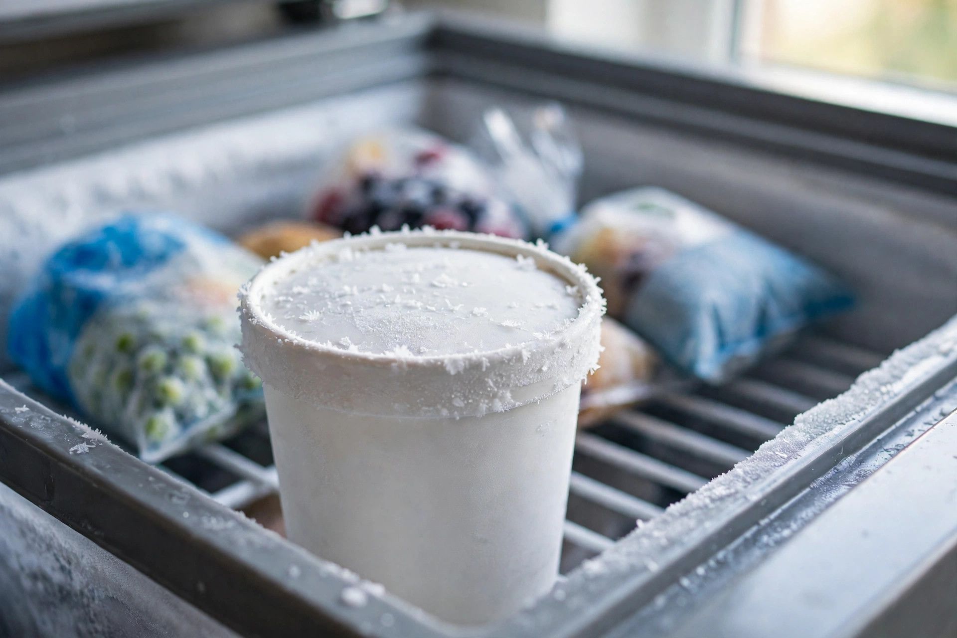 The filled vanilla pint with its lid on, freezing on a level shelf inside the freezer for 24 hours